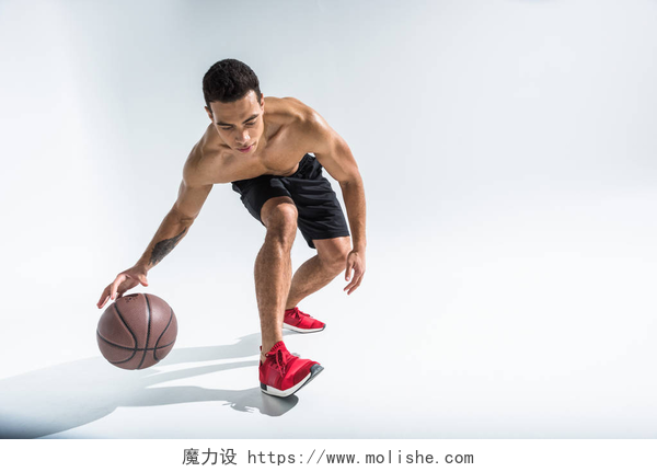 白色背景上打篮球的混合种族男子好看的运动混合种族男子在红色运动鞋打球上白色